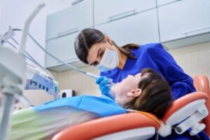 a hygienist cleaning a patient's teeth