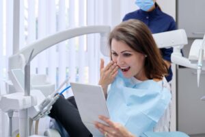 a woman smiling at the results of her dental implants