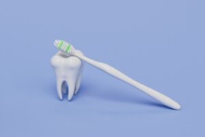 Picture of a white tooth figure and a toothbrush against a purple background.
