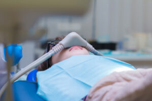 Picture of a dental patient undergoing nitrous oxide dental sedation during a procedure.