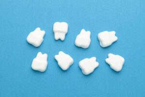 Picture of eight white tooth figures against a blue background.