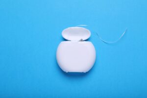 Picture of dental floss against a blue background.