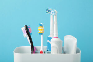Picture of manual and electric toothbrushes in a holder.